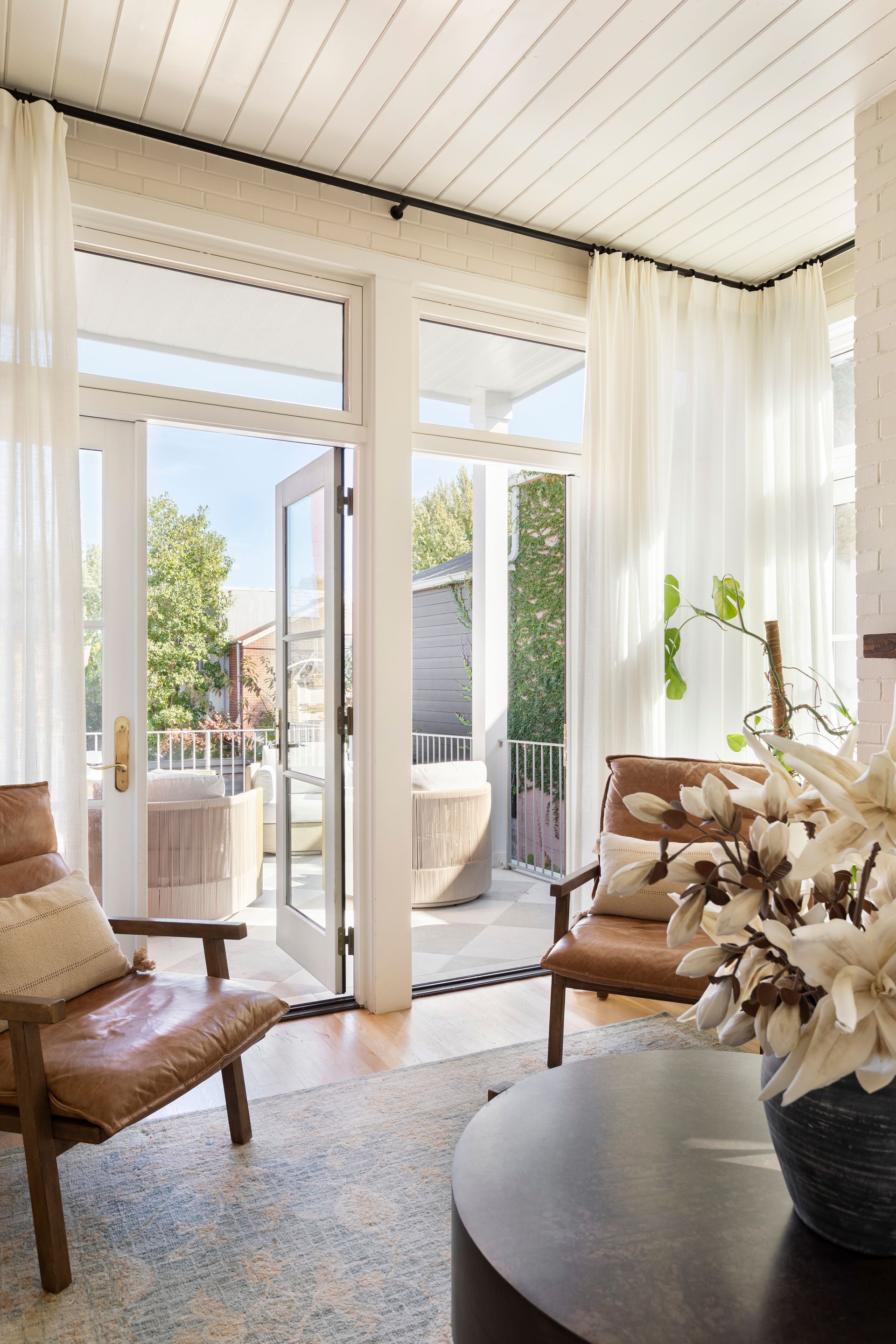Bright sitting room opening through French doors onto a covered terrace