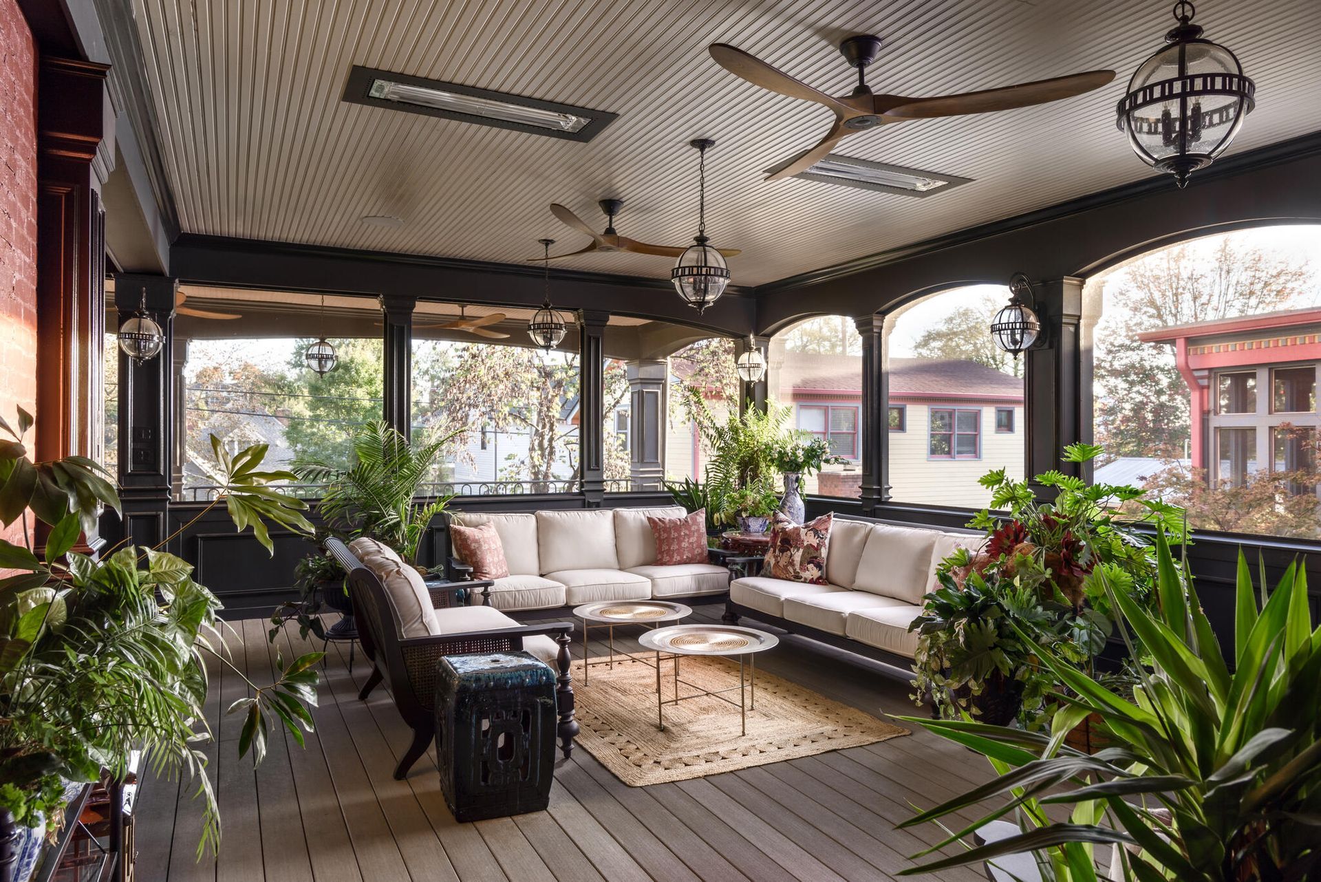 Restored covered porch with a panelled ceiling, globe lanterns and dark painted columns